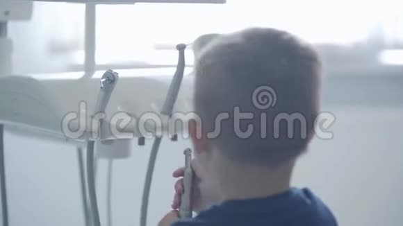 可爱的小男孩在牙医办公室玩拿着医疗工具托管儿童出诊医生牙科治疗视频的预览图