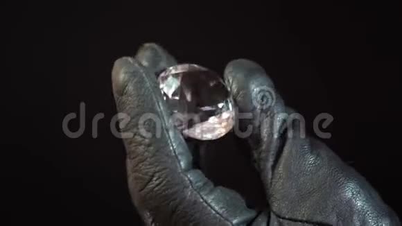 手里拿着大钻石戴手套的手握着一块巨大的宝石或钻石可能是便宜的假玻璃视频的预览图