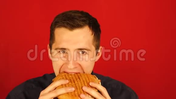 一个人在红色背景下努力地吃汉堡视频的预览图