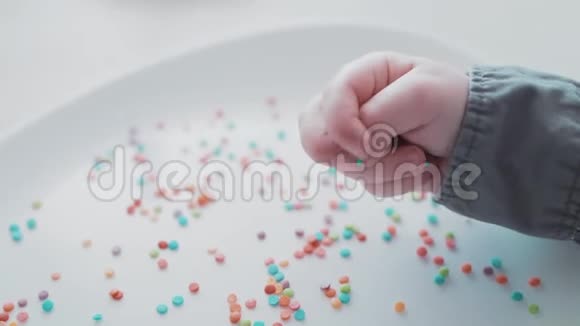 小孩子的手掌玩着五颜六色的浅糖视频的预览图