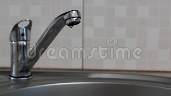 水龙头漏水厨房里的圆形金属水槽里滴水视频的预览图