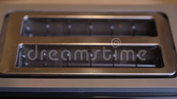 厨师把面包放进烤面包机里在厨房里为早餐准备热烤面包早上品尝面包视频的预览图