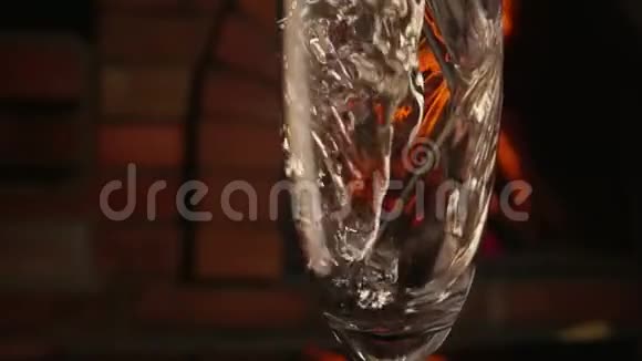 在壁炉旁边香槟正倒入玻璃杯中视频的预览图