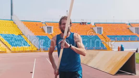 撑杆跳一个长胡子的运动员拿着撑杆开始跑视频的预览图
