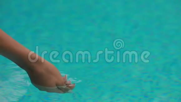 面目全非的女人把她的手放在游泳池里视频的预览图