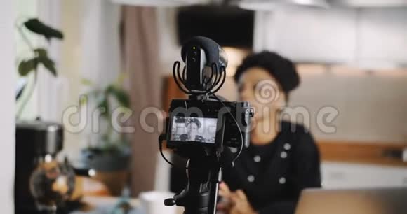特写专业相机正在拍摄年轻美丽的非洲博主女性创造新的vlog视频慢动作视频的预览图