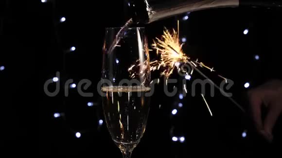 好香槟酒在玻璃旁边闪烁着明亮的火花背景中的灯光映衬着金色的香槟手拿香槟视频的预览图