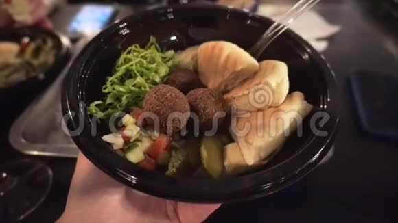 用皮塔面包和蔬菜沙拉配在一个旅行者手中的美味沙拉视频的预览图