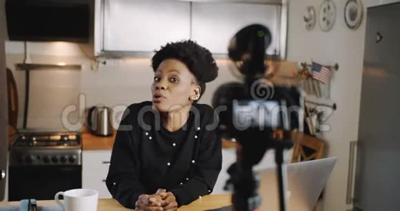 快乐年轻专业非洲女性时尚博客拍摄视频博客使用相机在家厨房慢动作视频的预览图