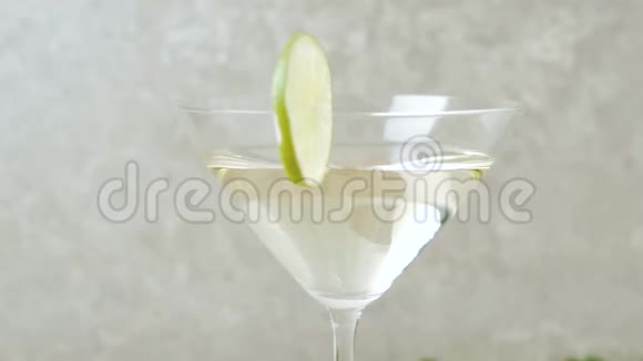 豪华马提尼玻璃边有甜马提尼和石灰的玻璃旋转在用鸡尾酒棒装饰的桌子上石灰视频的预览图