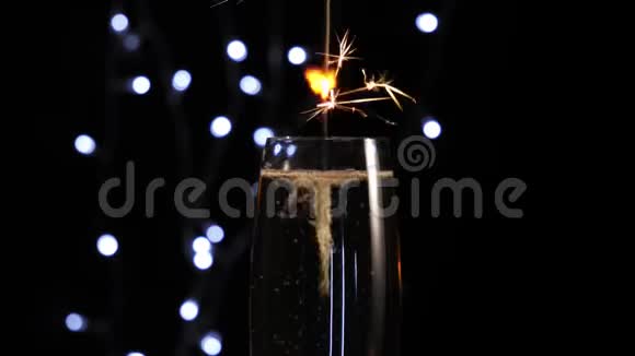 好香槟酒手把火花放在一个玻璃与香槟和搅拌酒精在背景灯长笛视频的预览图