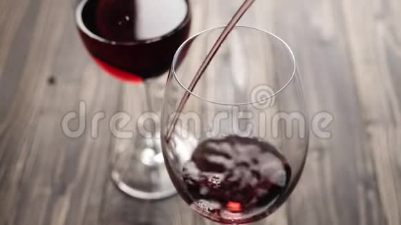 豪华红酒手从间歇泉中倒出美味的葡萄酒放在酒杯里红葡萄做的玫瑰酒视频的预览图