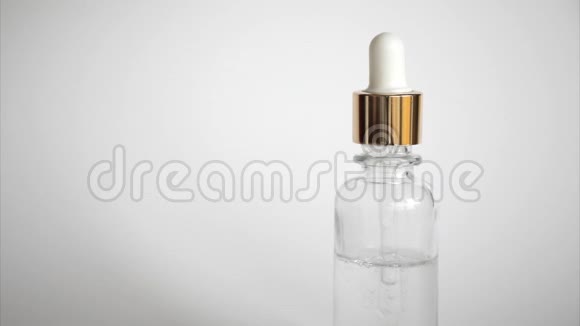 透明质酸滴从白色背景上的化妆品吸管中掉下来滴玻璃瓶视频的预览图