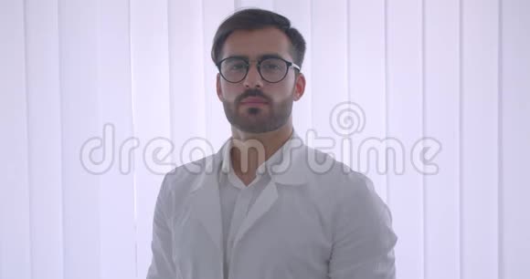 戴眼镜的白种人成年男医生的特写镜头双臂交叉在胸前看着镜头视频的预览图