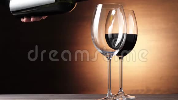 豪华红酒手从瓶子里倒出美味的葡萄酒在靠近第二杯的棕色背景下玫瑰酒视频的预览图