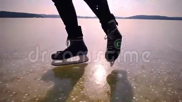 男子双脚冰滑冰曲棍球溜冰在清澈的湖面上自然滑冰视频的预览图