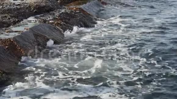 海浪在海滩上的岩石上破碎夏天的时候视频的预览图