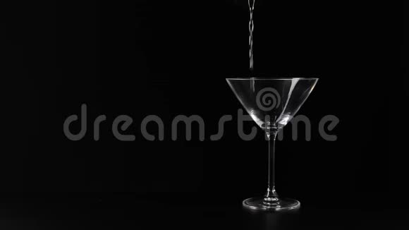 豪华马提尼手把甜马提尼倒入黑色背景的黑桌右侧的空玻璃中佛蒙特州视频的预览图
