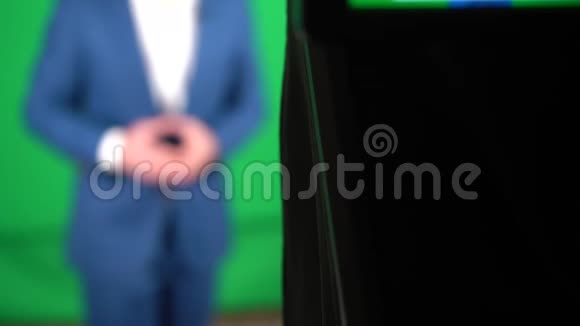 一个博主正在绿色背景上录制视频摄像机正在记录一个博主视频的预览图