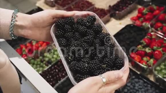 素食妇女选择黑莓在超市的商店柜台视频的预览图