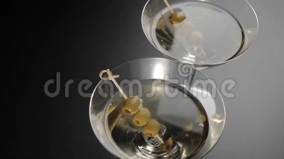 豪华马提尼黑桌上装饰着两杯马提尼里面有橄榄相机从一个玻璃上移动视频的预览图