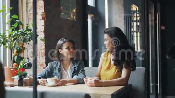 在咖啡馆里聊天的好朋友然后在围裙上聊天的女服务员视频的预览图