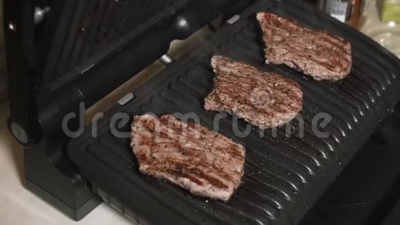 在家用电烤架上有中等罕见的多汁牛肉牛排视频的预览图