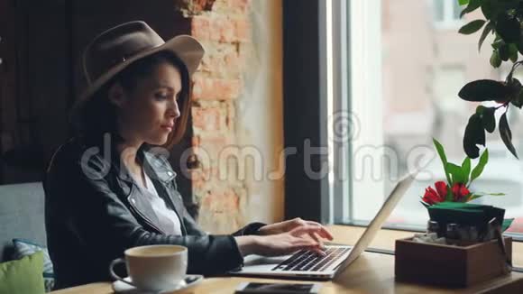 时尚的女商人在咖啡馆里用手提电脑打字一个人坐在桌子旁视频的预览图