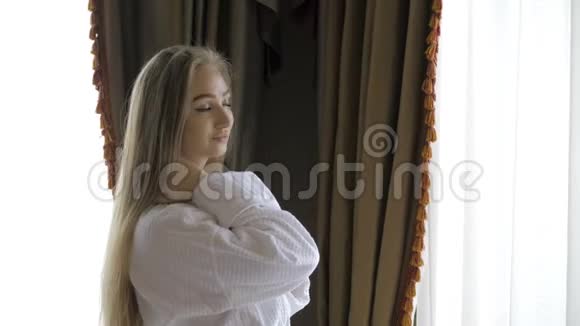 靠近窗户的女孩在旅馆房间里喝早咖啡视频的预览图