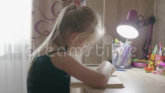 疲惫的女学生在书桌上看书教育和学校理念视频的预览图
