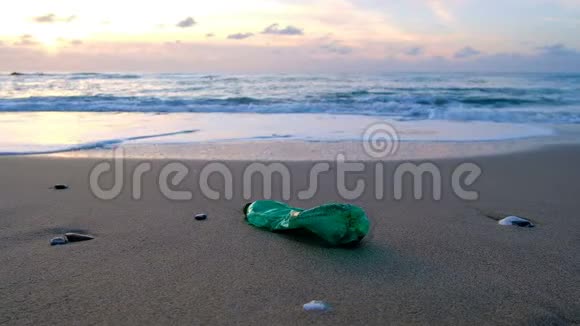 日落时分年轻人从海边捡起塑料瓶污染概念视频的预览图