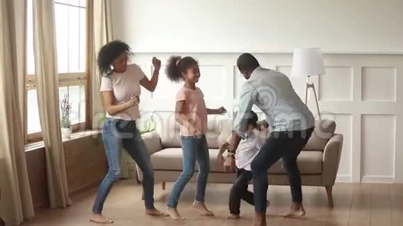 有孩子的非洲家庭积极地在家跳舞视频的预览图