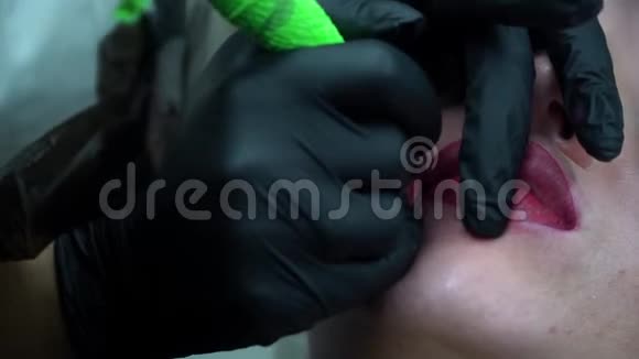 美容师在女人的嘴唇上做永久的化妆视频的预览图