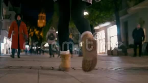 秋天的夜晚在城市大街外漫步的靴子中的女性脚视频的预览图