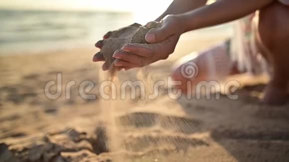 女人拿着沙子放在海滩上视频的预览图