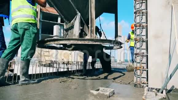 建筑工人把水泥倒在建筑工地的地板上视频的预览图