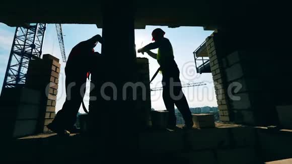 人们在建筑工地工作铺砖视频的预览图