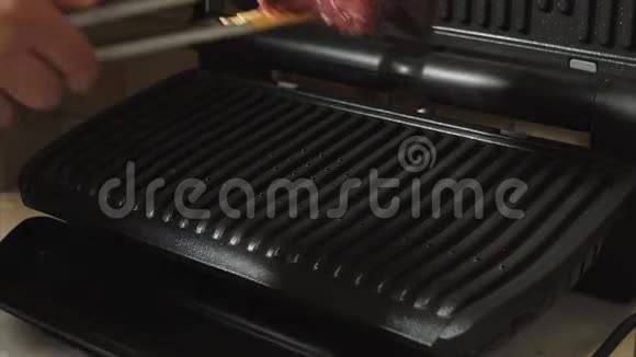 男人把新鲜的辣牛肉肉放在电子烤架上做牛排视频的预览图