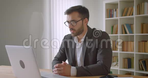 戴眼镜的成年英俊白种人商人的特写肖像他在笔记本电脑上打了一个视频电话视频的预览图