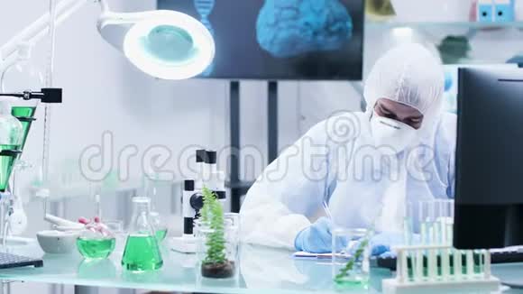 在高端生物化学实验室里一位穿着工作服的科学家正在做笔记视频的预览图