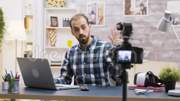 著名年轻的vlogger说话时在笔记本电脑上打字视频的预览图
