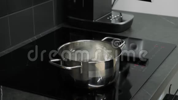 把盐水放在智能厨房的感应板上雌性或雄性向水中加入盐关闭添加SPI的侧面视图视频的预览图