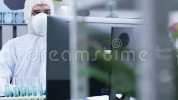 穿白色工作服的男性科学家在电脑上工作的肖像视频的预览图