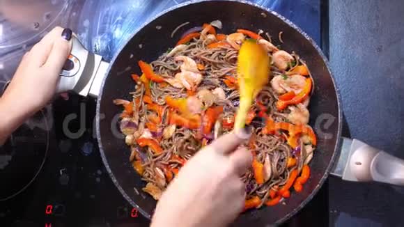 在肮脏的炉子上用蔬菜和虾搅拌面视频的预览图