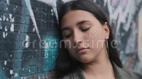 墙上涂鸦的年轻时髦女孩的肖像特写视频的预览图