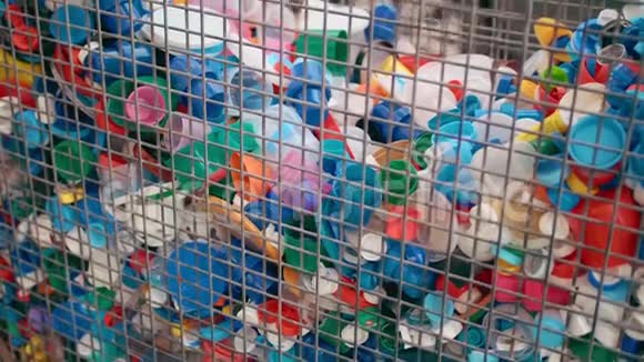 很多塑料瓶盖放在铁笼子里收集塑料收集塑料垃圾的概念视频的预览图