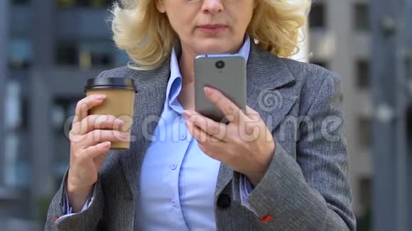 老太太在咖啡休息时使用手机对商务应用程序不满意视频的预览图