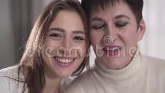 快乐白人母女看着镜头微笑的肖像年轻快乐的女人和她年轻的女人视频的预览图