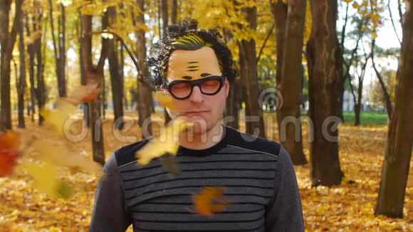 树枝在秋天公园里打了一个戴着面具的不满的人的眼睛有趣的时刻视频的预览图