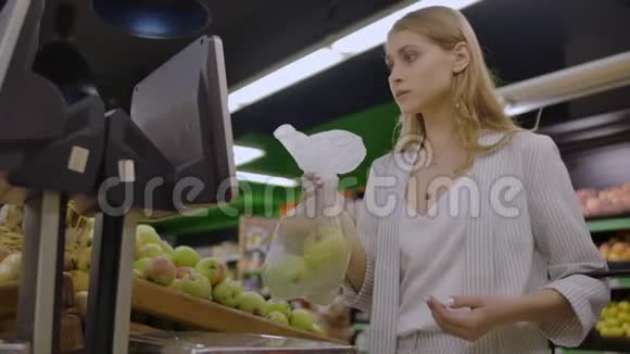 中年妇女在超市里重一袋苹果视频的预览图